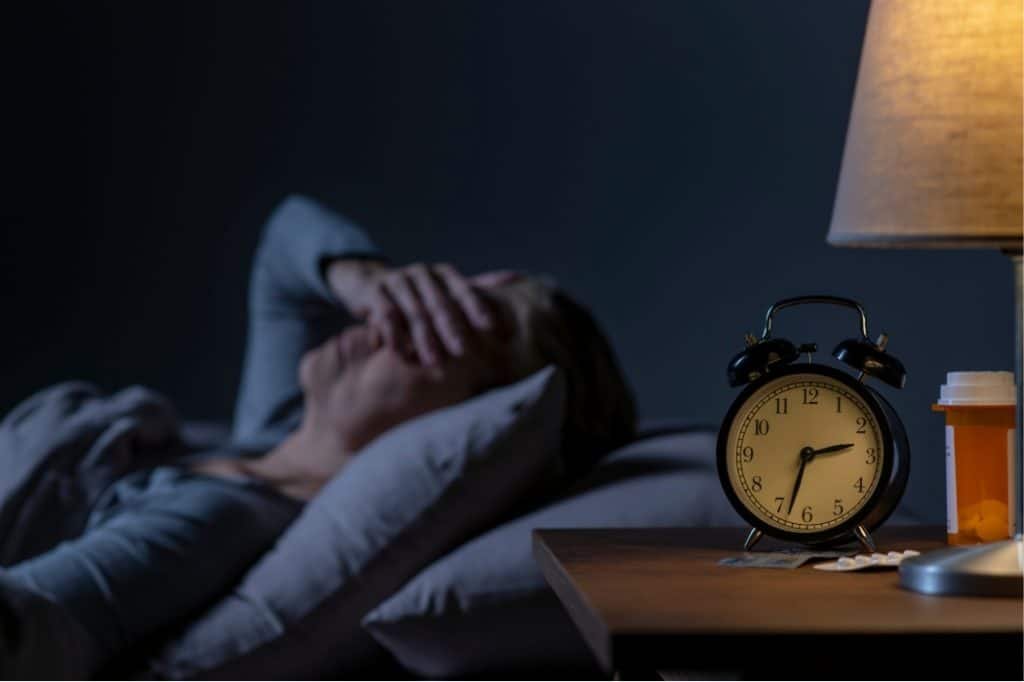 A woman struggles to sleep as her hip pain intensifies